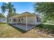 Single-wide home with covered patio and landscaping at 705 Devon Dr, Lady Lake, FL 32159