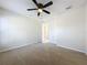 Bright bedroom with ceiling fan, neutral walls, and door to bathroom at 733 Cherry Laurel St, Minneola, FL 34715