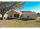 Tan house exterior with screened porch and brown roof at 733 Cherry Laurel St, Minneola, FL 34715