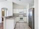 White cabinets, granite countertops, and stainless steel appliances in this galley kitchen at 733 Cherry Laurel St, Minneola, FL 34715