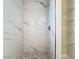 Large shower with marble-style tile and a built-in shelf at 733 Cherry Laurel St, Minneola, FL 34715