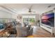 Relaxing living room featuring hardwood floors, a large TV, and ample natural light at 7592 Se 170Th Longview Ln, The Villages, FL 32162