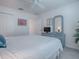 Calm bedroom featuring blue dresser, ceiling fan, and light-colored decor for peaceful rest at 802 Nancy Dr, The Villages, FL 32163