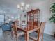 Dining room features a wooden table with seating for four, a chandelier, and a hutch displaying glassware at 802 Nancy Dr, The Villages, FL 32163