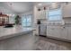 Modern kitchen featuring white cabinets, stainless steel appliances, and a view to the outdoor dining area at 802 Nancy Dr, The Villages, FL 32163