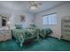 Guest bedroom with twin beds, green carpet and a decorative shelving unit at 8460 Se 137Th Loop, Summerfield, FL 34491