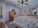 Main bedroom with wood flooring, large bed, and an ensuite bathroom at 8460 Se 137Th Loop, Summerfield, FL 34491