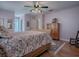 Main bedroom with wood flooring, large bed, and an ensuite bathroom at 8460 Se 137Th Loop, Summerfield, FL 34491