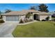 Single-story home with attached garage and well-manicured lawn at 8460 Se 137Th Loop, Summerfield, FL 34491