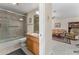 Bathroom adjacent to a living room with a tiled shower and oak vanity at 85 Golfview Cir, Umatilla, FL 32784