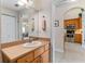 Bathroom featuring a wooden vanity adjacent to a kitchen with stainless steel appliances at 85 Golfview Cir, Umatilla, FL 32784