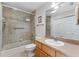 Bright bathroom featuring a tiled shower/tub combo and a wooden vanity with large mirror at 85 Golfview Cir, Umatilla, FL 32784