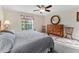 Bedroom with a sunny window, wooden dresser, and cozy decor at 85 Golfview Cir, Umatilla, FL 32784