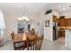 Dining room featuring wooden table set with a pendant light above. Kitchen and additional living space in view at 85 Golfview Cir, Umatilla, FL 32784