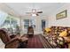 Cozy living room with large windows, a ceiling fan, and plush seating at 85 Golfview Cir, Umatilla, FL 32784