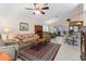 Open-concept living room with tile flooring, a ceiling fan, and a view into the kitchen and dining area at 85 Golfview Cir, Umatilla, FL 32784