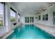 Relaxing indoor pool area, featuring a water feature and ceiling fans at 858 Pinckney Ln, The Villages, FL 32162