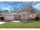 Front view of a single-story house with a garage and neat landscaping at 870 Vindale Rd, Tavares, FL 32778