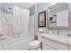 Well-lit bathroom with shower-tub combo, vanity with granite counters, and a framed mirror at 893 Fenwick Loop, The Villages, FL 32163