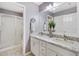 Bright bathroom featuring double sink vanity with granite countertops and a glass door shower at 893 Fenwick Loop, The Villages, FL 32163