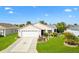 Single-story home with a well-manicured lawn and charming landscaping at 893 Fenwick Loop, The Villages, FL 32163