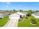 Well-maintained home exterior showcasing a green lawn, tidy landscaping, and two car garage at 893 Fenwick Loop, The Villages, FL 32163