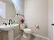 Small bathroom with toilet and pedestal sink at 96 Silver Maple Rd, Groveland, FL 34736