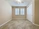 Bright bedroom featuring tile floors, double closet, and window shutters at 96 Silver Maple Rd, Groveland, FL 34736