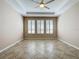 Empty bonus room with tile floors, ceiling fan, and large windows with shutters at 96 Silver Maple Rd, Groveland, FL 34736