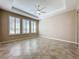 Empty bonus room with tile floors, ceiling fan, and large windows with shutters at 96 Silver Maple Rd, Groveland, FL 34736