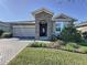 Charming exterior view of the house featuring a stone archway and meticulously manicured landscaping at 96 Silver Maple Rd, Groveland, FL 34736