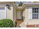 Inviting front entrance with a white door and landscaping at 3001 Saint Thomas Ln, The Villages, FL 32162