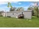 Gray mobile home with a grassy backyard and wooden steps at 00 Mark Ave, Lady Lake, FL 32159