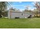 Gray mobile home with a grassy backyard and wooden steps at 00 Mark Ave, Lady Lake, FL 32159