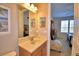 Bathroom featuring a granite vanity, lighting, framed art and view into the bedroom at 113 Pecorri Ct, Auburndale, FL 33823