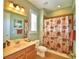 Clean bathroom with decorative shower curtain, ample lighting, and tile flooring at 113 Pecorri Ct, Auburndale, FL 33823