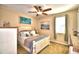 Bright bedroom features a ceiling fan, a double bed, bedside table, and beach-themed artwork at 113 Pecorri Ct, Auburndale, FL 33823