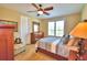 Comfortable bedroom featuring a ceiling fan, window with plantation shutters and stylish furnishings at 113 Pecorri Ct, Auburndale, FL 33823
