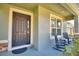 Front entrance with rocking chairs and lush landscaping at 113 Pecorri Ct, Auburndale, FL 33823