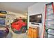 Spacious garage with ample storage, a television, a rolling ladder, and 2 parked cars at 113 Pecorri Ct, Auburndale, FL 33823