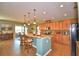 Modern kitchen with island, stainless steel appliances, and wood cabinets at 113 Pecorri Ct, Auburndale, FL 33823