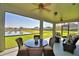 This screened lanai features comfortable seating with views of a tranquil pond at 113 Pecorri Ct, Auburndale, FL 33823