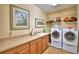 Functional laundry room features cabinetry, counter space, utility sink, washer, dryer, and shelving at 113 Pecorri Ct, Auburndale, FL 33823