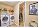 Clean laundry area equipped with modern washer, dryer and a closet with shelving at 113 Pecorri Ct, Auburndale, FL 33823