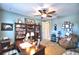 Large home office with ceiling fan, built-in bookshelves, hardwood desk, and comfortable sitting area at 113 Pecorri Ct, Auburndale, FL 33823