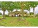 Beautiful pool access area with well-manicured lawn and mature trees providing shade at 113 Pecorri Ct, Auburndale, FL 33823