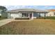 One-story home with gray exterior, white garage door, and red front door at 11579 Se 172Nd Loop, Summerfield, FL 34491