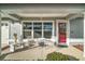 Inviting front porch with seating area, red door, and landscaping at 11579 Se 172Nd Loop, Summerfield, FL 34491