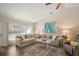 Living room with beige sectional sofa, wood floors, and decorative accents at 11579 Se 172Nd Loop, Summerfield, FL 34491