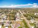 Expansive aerial view of a neighborhood showcasing a serene residential area with mature trees and beautiful homes under a bright blue sky at 11744 Oswalt Rd, Clermont, FL 34711